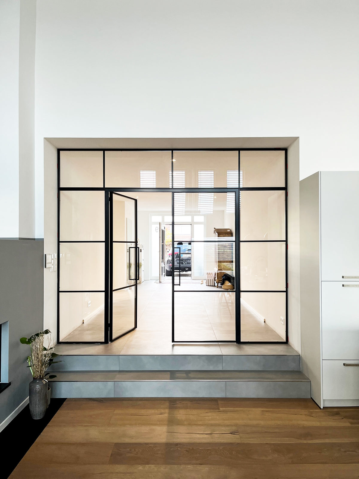 Zweiflügelige Loft-Drehtür aus Stahl und Glas mit Seitenteilen und Oberlicht